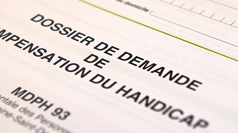 Dossier de demande de compensation du handicap sur un bureau