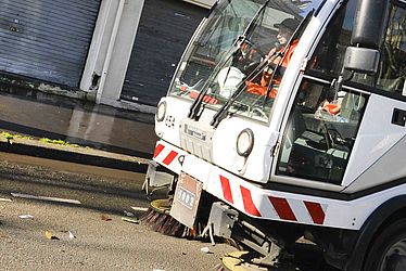 Un camion balais mécanique de Pantin nettoyant une rue de la ville.