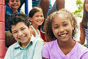 Un groupe d'enfant prennent la pose dans une forêt.