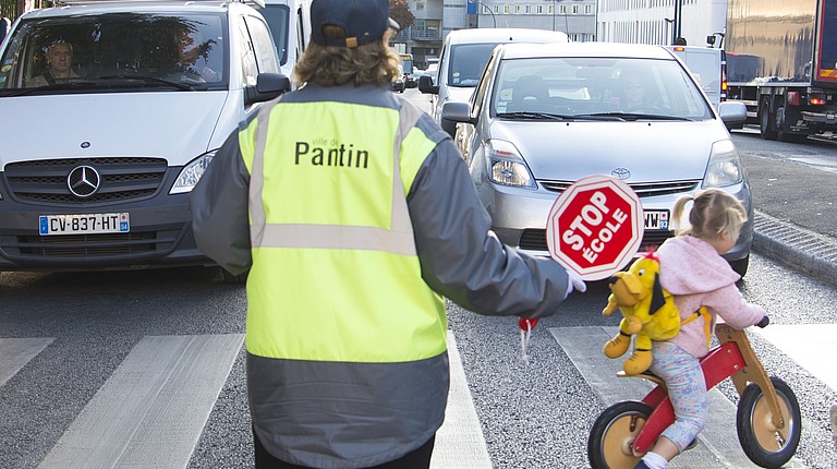 Un agent de traversée des écoles sécurise la traversée d'enfants aux abords d'une école de Pantin