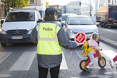 Un agent de traversée des écoles sécurise la traversée d'enfants aux abords d'une école de Pantin