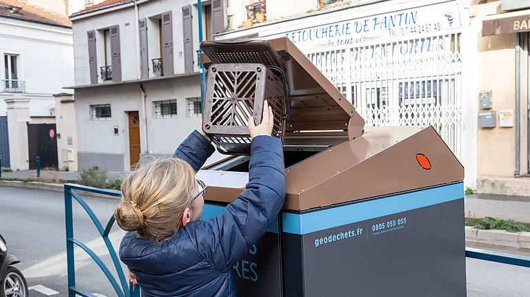 Un enfant jète ses déchets alimentaires dans un des 800 points d’apport volontaire réservés aux déchets alimentaires.