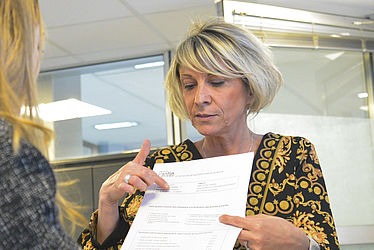 Un agent du pôle facturation périscolaire et recouvrement de Pantin montre à une femme son attestation de calcul du quotient familial